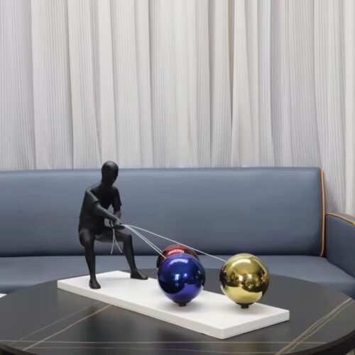 Black man pulling balls figurine